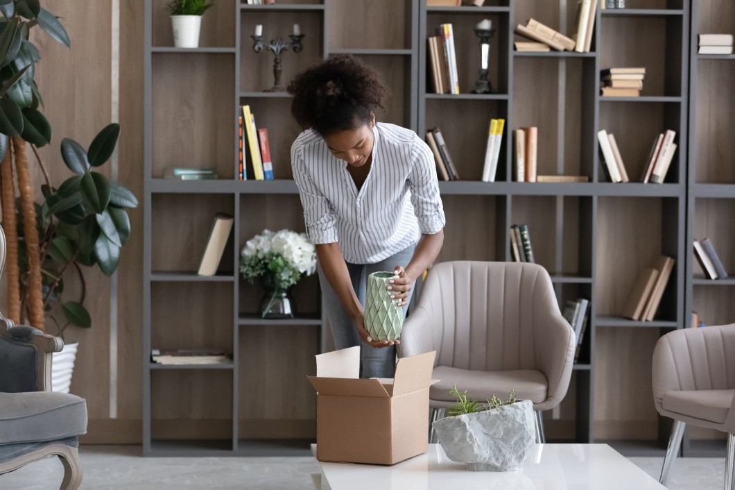 Photo of a woman who is rediscovering her love for interior design and unboxing a unique vase for her home.